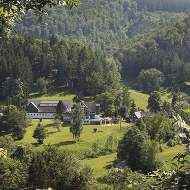 Blick auf unser Hotel im Sauerland Blick auf ein Hotel, Wiese und Wald